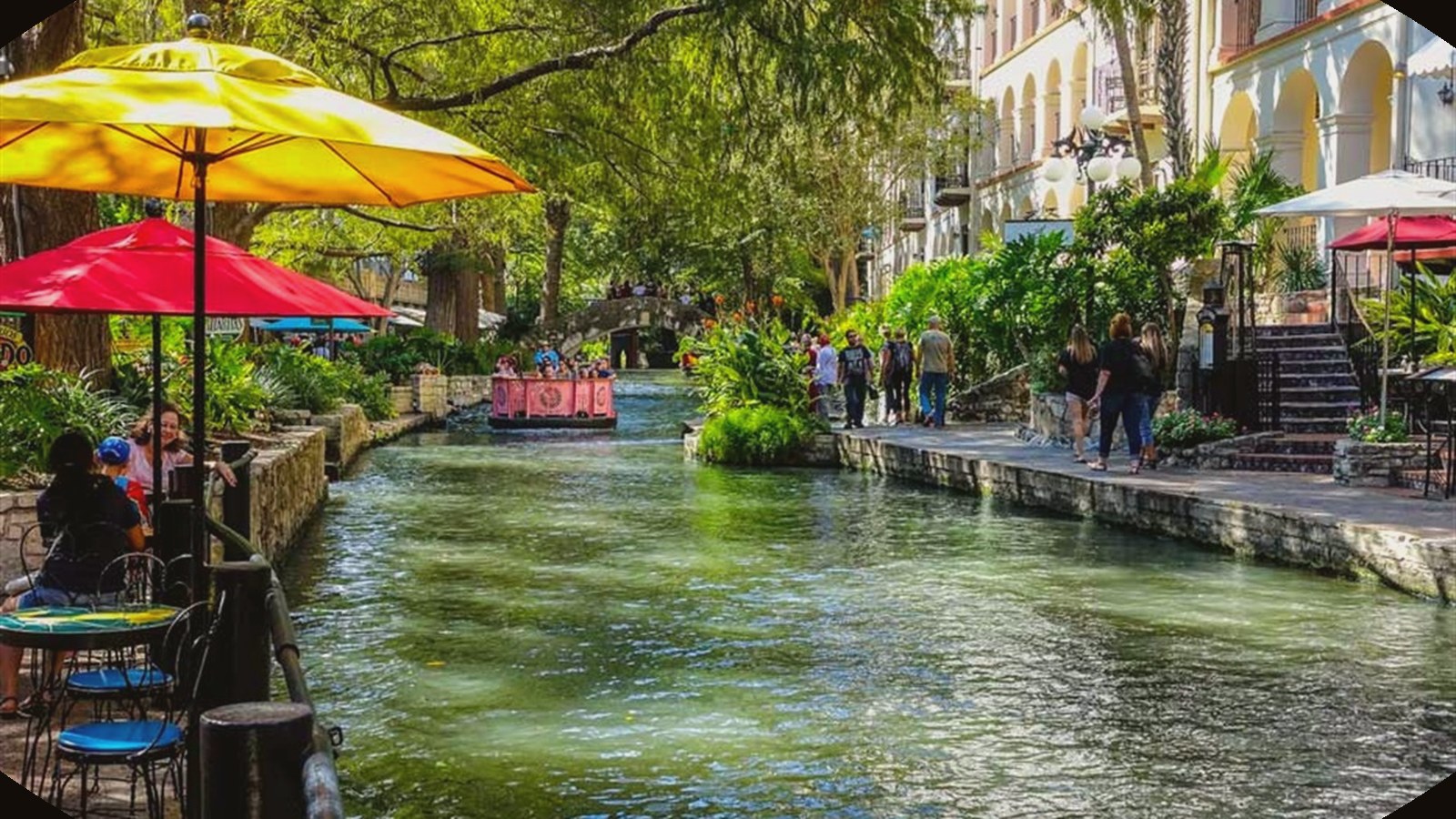 San Antonio River Walk with restaurants, umbrellas, water, and downtown energy